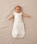 Baby sleeping with arms out in a ergoPouch Cocoon Swaddle Sack 2.5 TOG Oatmeal Marle