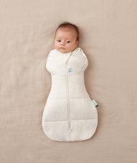 Newborn wearing an ergoPouch Cocoon Swaddle Sack 3.5 TOG Oatmeal Marle