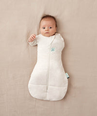 Baby wearing a ergoPouch Cocoon Swaddle Sack 3.5 TOG Oatmeal Marle, transitioning to arms out sleeping