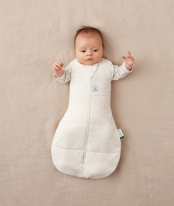 Baby sleeping with arms out in a ergoPouch Cocoon Swaddle Sack 3.5 TOG Oatmeal Marle