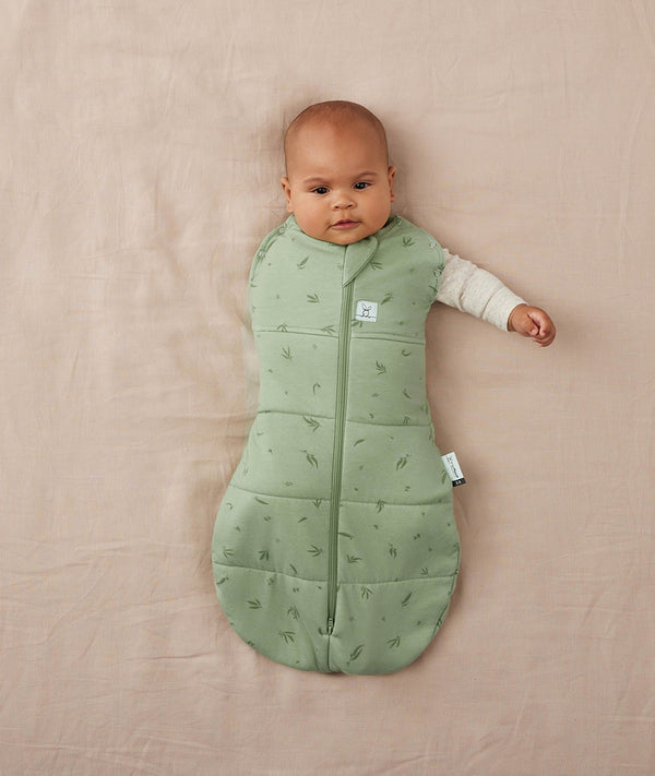 Baby wearing a ergoPouch Cocoon Swaddle Sack 2.5 TOG Willow, transitioning to arms out sleeping