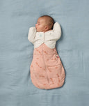 Newborn being swaddled in an ergoPouch Cocoon Swaddle Sack 2.5 TOG Elephant Parade with a Butterfly Cardi Oatmeal Marle over the top, for arms up sleeping