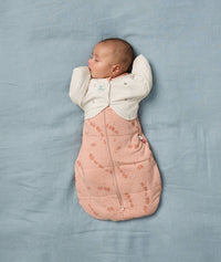 Newborn being swaddled in an ergoPouch Cocoon Swaddle Sack 2.5 TOG Elephant Parade with a Butterfly Cardi Oatmeal Marle over the top, for arms up sleeping