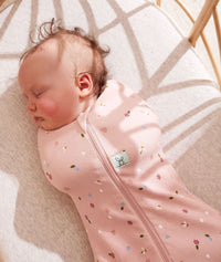 Close up of a newborn being swaddled in ergoPouch Cocoon Swaddle Sack 1.0 TOG Daisies