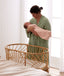 Baby swaddled by mothers wearing a ergoPouch Cocoon Swaddle Sack 1.0 TOG Daisies