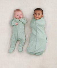 Baby wearing ergoPouch Long Sleeve Romper in Sage and Cocoon Swaddle Bag in Sage