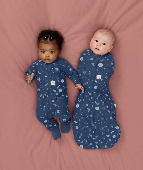 Two babies wearing Starbeam sleepwear, one in Long Sleeve Romper 1.0 TOG and the other in Cocoon Swaddle Sack 1.0 TOG