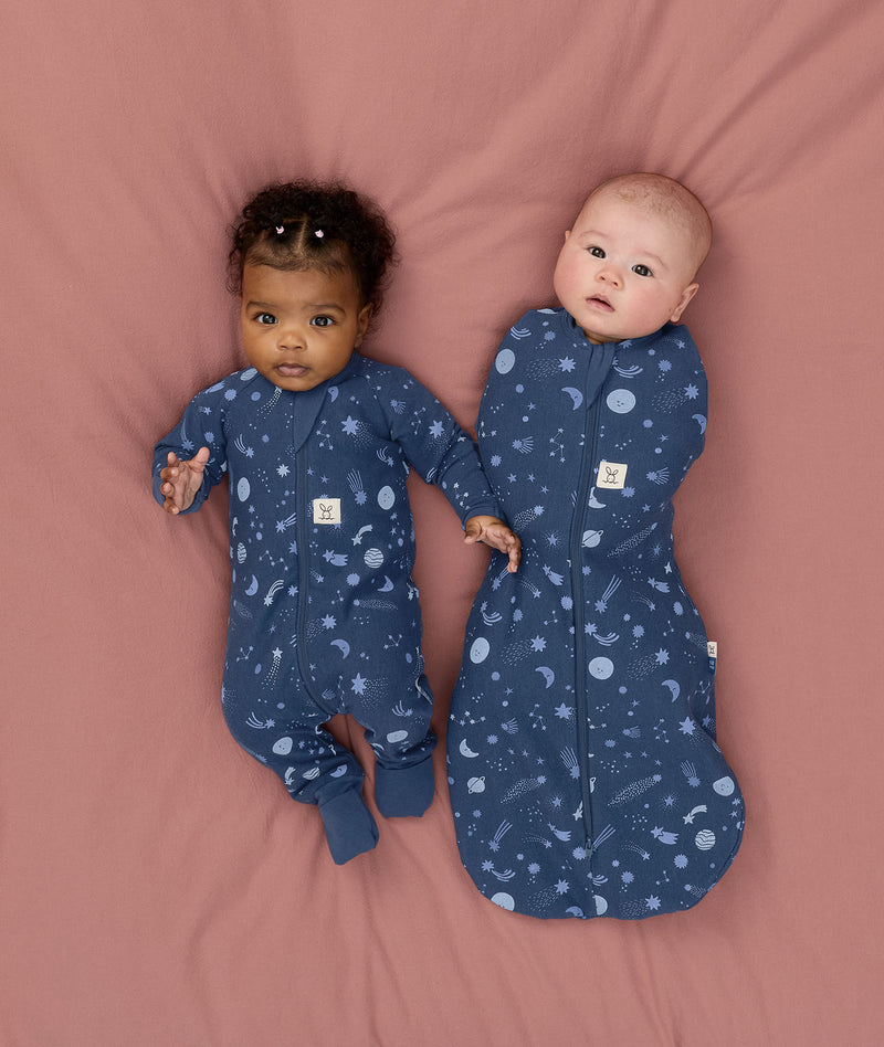 Two babies wearing Starbeam sleepwear, one in Long Sleeve Romper 1.0 TOG and the other in Cocoon Swaddle Sack 1.0 TOG