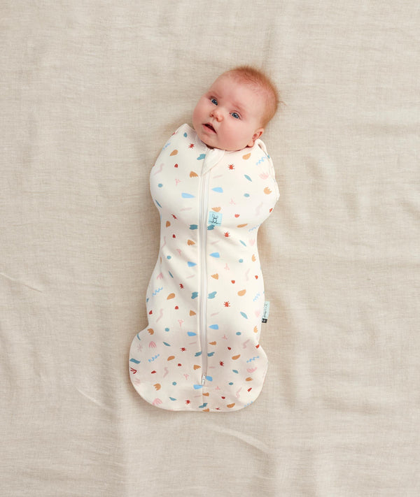Newborn swaddled in ergoPouch Cocoon Swaddle Sack 0.2 TOG Desert Bloom, perfect for summer