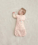 Newborn in a ergoPouch Cocoon Swaddle Sack 1.0 TOG Cute Fruit, transitioning to arms out sleeping 
