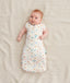 Newborn in a ergoPouch Cocoon Swaddle Sack 1.0 TOG Desert Bloom, transitioning to arms out sleeping 