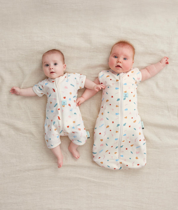 Newborns dressed in ergoPouch Cocoon Swaddle Sack 1.0 TOG and Long Sleeve Romper Desert Bloom