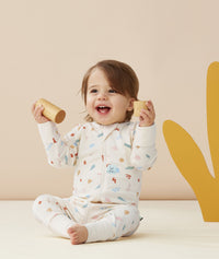 Infant smiling whilst playing with blocks wearing ergoPouch Long Sleeve Romper 0.2 TOG Desert Bloom