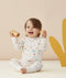 Infant smiling whilst playing with blocks wearing ergoPouch Long Sleeve Romper 0.2 TOG Desert Bloom