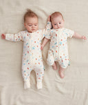 Smiling infants wearing  ergoPouch Long Sleeve Romper 0.2 TOG Desert Bloom and  Sleep Sack 0.2 TOG Desert Bloom