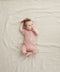 Newborn baby lying on her back wearing a ergoPouch Short Sleeve Romper 0.2 TOG Berries