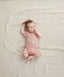 Newborn baby lying on her back wearing a ergoPouch Short Sleeve Romper 0.2 TOG Berries