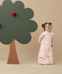 Child standing in an ergoPouch Sleep Suit Sack 2.5 TOG Cute Fruit, a warm sleeping bag that converts to a sleeping bag with legs