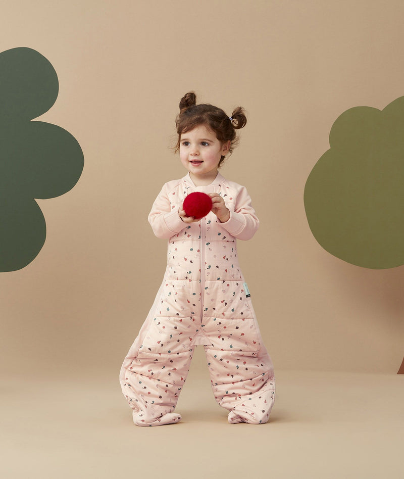 a toddler wearing a ergoPouch Sleep Suit Sack 3.5 TOG Cute Fruit, ideal for winter months