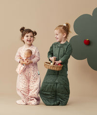 Two children standing in an ergoPouch Sleep Suit Sack 3.5 TOG Veggie Patch and Cute Fruit, a warm sleeping bag that converts to a sleeping bag with legs