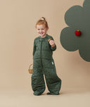 A cheeky smiling child wearing a warm ergoPouch Sleep Suit Sack 3.5 TOG Veggie Patch, great for the winter