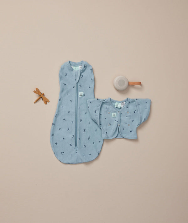 Flatlay shor of ergoPouch Cocoon Swaddle Sack 1.0 TOG Dragonflies, Butterfly Cardi Dragonflies, White Noise machine, the perfect newborn starter essentials