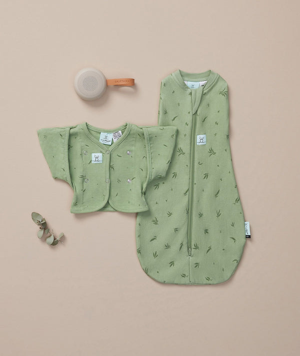ergoPouch Butterfly Cardi Willow on top of matching Cocoon Swaddle Sack and white noise machine
