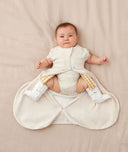 Baby wearing an ergoPouch Hip Harness Cocoon Swaddle Sack 1.0 TOG Oatmeal Marle with legs out