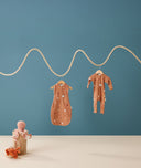 Hanging product shot of ergoPouch Cocoon Swaddle Sack 0.2 TOG and Long Sleeve Romper Sunny