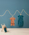 Flatlay of ergoPouch Short Sleeve Pajamas 0.2 TOG Sunny and Sleep Suit Sack 1.0 TOG Ocean Blue