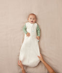 Infant lying in a crib wearing an ergoPouch Sleeping Sack 0.2 TOG Oatmeal Marle perfect for the summer