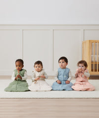 Four infants sitting in ergoPouch Sleep Sack 2.5 TOG Sleeved Daisies, Dragonflies, Willow and Oatmeal Marle