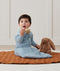 Newborn sitting, wearing an ergoPouch Sleeping Sack 3.5 TOG Dragonflies