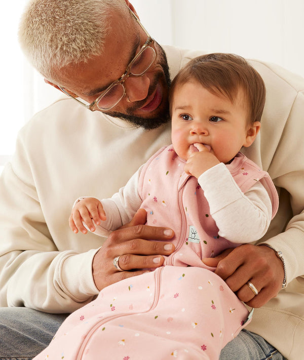 Parent holding infant who is wearing a sleep-sack-1-0-tog-daisies