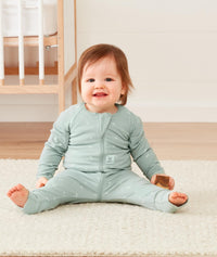 Baby wearing ergoPouch Long Sleeve Romper in Sage