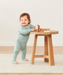 Infant wearing ergoPouch Long Sleeve Romper in Sage