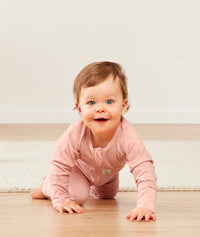 Infant crawling, wearing an ergoPouch Long Sleeve Romper 0.2 TOG Berries