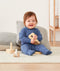 Infant sitting, wearing an ergoPouch Long Sleeve Romper 0.2 TOG Night Sky
