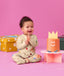 Smiling infant wearing  ergoPouch Long Sleeve Romper 1.0 TOG Birthday Blobs