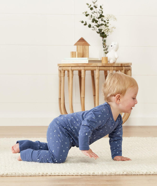Infant crawling wearing ergoPouch Long Sleeve Romper 0.2 TOG Night Sky