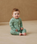 Infant sitting, wearing an ergoPouch Long Sleeve Romper 1.0 TOG Sweet Orchard