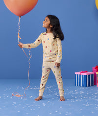 Preschooler holding a balloon wearing ergoPouch Long Sleeve Pajamas 0.2 TOG in Birthday Blobs 