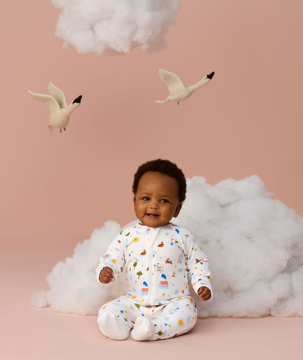 Infant sitting in ergoPouch Long Sleeve Romper 1.0 TOG Daydream