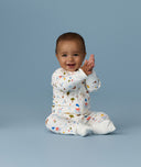 Happy infant sitting in an ergoPouch Long Sleeve Romper 1.0 TOG Daydream