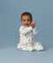 Happy infant sitting in an ergoPouch Long Sleeve Romper 1.0 TOG Daydream