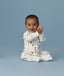 Happy infant sitting in an ergoPouch Long Sleeve Romper 1.0 TOG Daydream