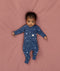 Baby lying in an ergoPouch Long Sleeve Romper 1.0 TOG Daydream with the fold-over cuffs