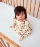 Baby sitting down looking at the camera wearing ergoPouch Long Sleeve Romper 1.0 TOG in Bon Appetit
