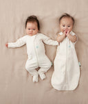 Two babies in ergoPouch Cocoon Swaddle Sack 1.0 TOG Oatmeal Marle and Long Sleeve Romper Oatmeal Marle