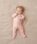 Newborn wearing an ergoPouch Long Sleeve Romper 1.0 TOG Daisies